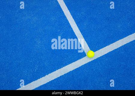ball on the baseline of a blue paddle tennis court Stock Photo