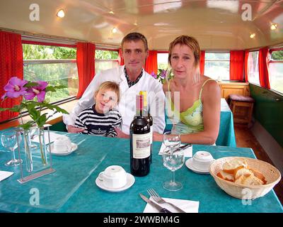 IAN DERRICK ON HIS CONVERTED LONDON BUS IN THE WINE REGIONS OF BORDEAUX. WITH WIFE CHANTELLE AND SON TOM.  IAN DERRICK BOUGHT A LONDON BUS IN MAY 2001 FROM A DEPOT IN KENT AND DROVE IT ACROSS THE CHANNEL TO THE WINE REGIONS OF BORDEAUX. HE HAS CONVERTED IT INTO A RESTAURANT, AND DRIVES IT AROUND THE TRADITIONAL WINE REGIONS, SERVING TRADITIONAL ENGLISH FOOD SUCH AS FISH AND CHIPS, CURRY AND FRUIT CRUMBLE TO THE FRENCH.  PICTURE: GARYROBERTS/WORLDWIDEFEATURES.COM Stock Photo