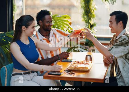 Diverse group of young people having cocktails and appetizers in restaurant Stock Photo