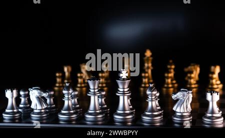 Silver and golden chess pieces on reflective board. Chessmen on a black background. Chess game Stock Photo