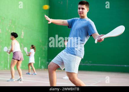 Young man playing Basque pelota on outdoor pelota court Stock Photo