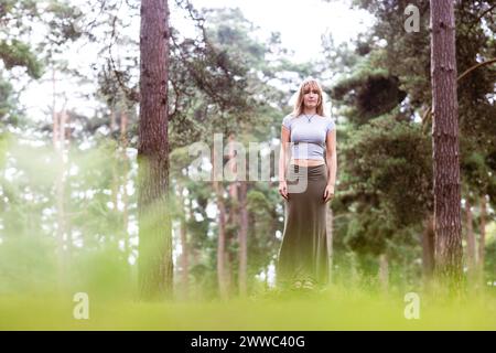 Young woman standing in front of trees Stock Photo