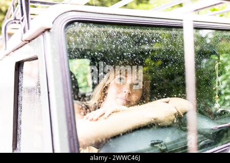 Woman sitting and looking through car window Stock Photo