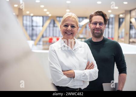 Happy businessman and businesswoman standing in office Stock Photo