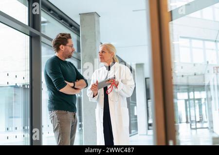 Doctor holding tablet PC and discussing with man in hospital Stock Photo