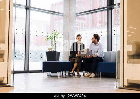 Mature businessman discussing over laptop with colleague in office Stock Photo