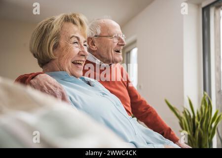 Happy senior couple sitting in living room at home Stock Photo