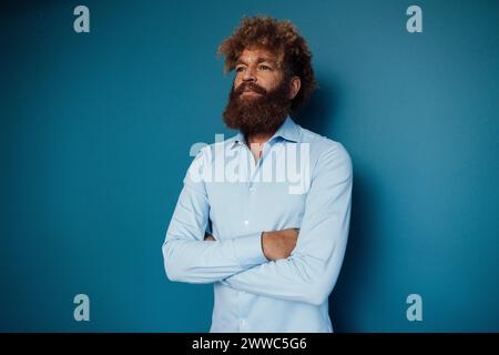 Mature man wearing blue shirt and standing in front of wall Stock Photo