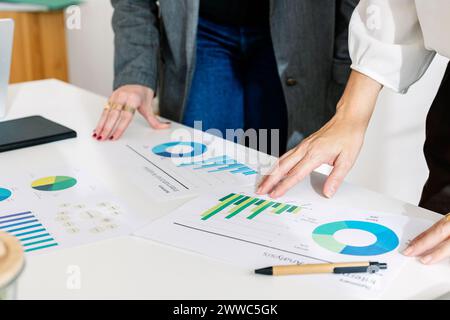 Businesswoman discussing over charts and graphs with colleague in office Stock Photo