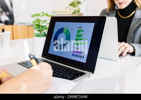 Businesswoman working and analyzing charts on laptop Stock Photo
