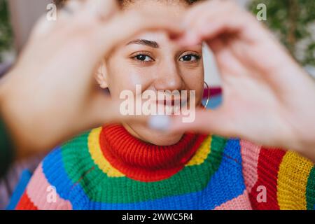 Smiling woman gesturing heart shape Stock Photo