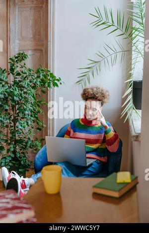 Smiling freelancer working on laptop at home Stock Photo