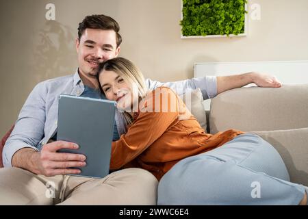 Loving young couple using tablet PC at home Stock Photo