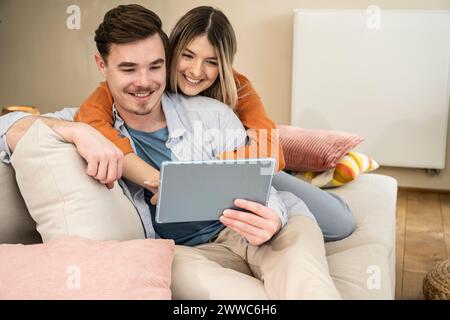 Happy couple using tablet PC at home Stock Photo