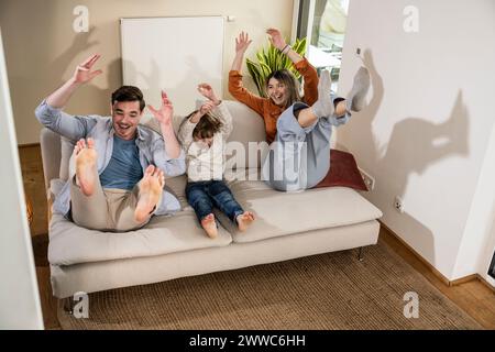 Cheerful family enjoying together on sofa at home Stock Photo