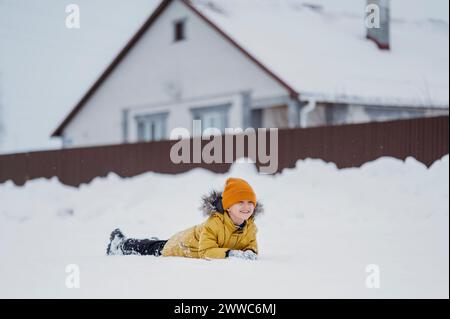 Carefree boy lying down on snow in winter Stock Photo