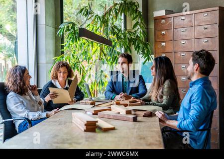 Creative professionals having discussion over wooden samples on desk in office Stock Photo