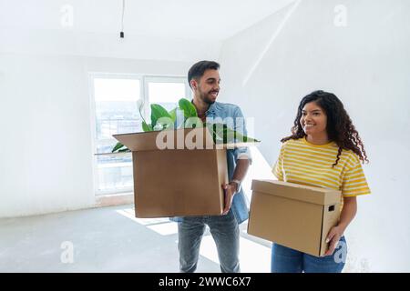 Smiling couple carrying cardboard boxes at new home Stock Photo