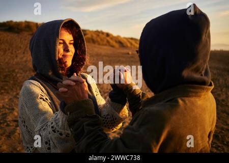Happy couple holding hands and standing at beach Stock Photo