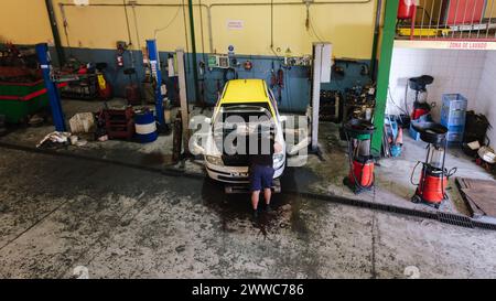 Mechanic working on car engine at workshop Stock Photo
