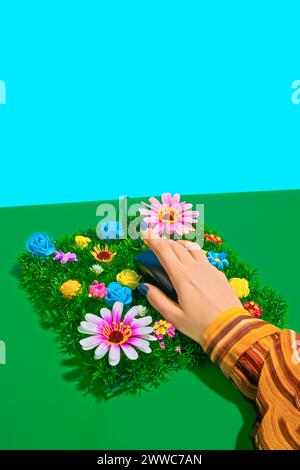 Hand of businesswoman holding computer mouse on spring flowers Stock Photo