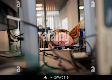 Tired businesswoman taking nap in office Stock Photo