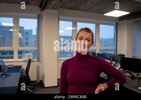 Smiling young businesswoman standing in office Stock Photo
