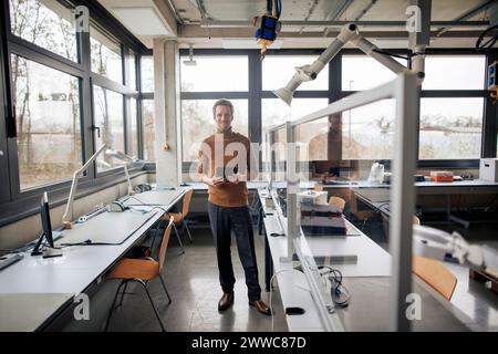Smiling engineer holding tablet PC at workshop Stock Photo