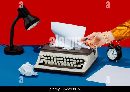 Writer removing paper from typewriter on desk Stock Photo