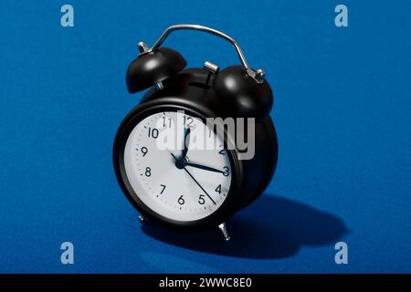 Retro style alarm clock on blue background Stock Photo