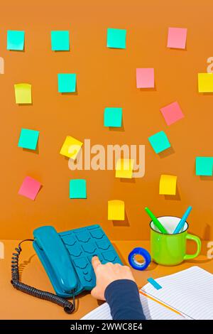 Hand of saleswoman pressing buttons on blue telephone Stock Photo