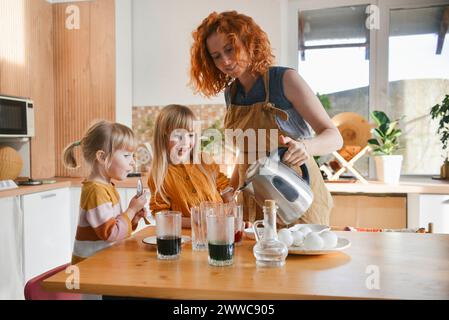 Mother preparing dye to paint Easter eggs at home Stock Photo