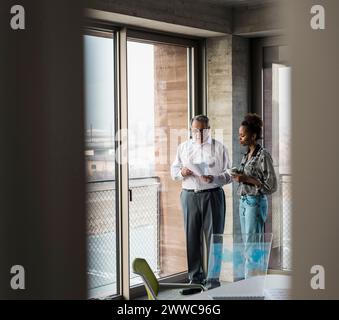 Business colleagues discussing over document at workplace Stock Photo