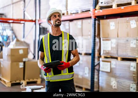 Smiling worker examining inventory with tablet PC at warehouse Stock Photo