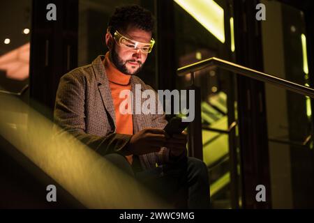 Smiling man wearing smart glasses and using smart phone Stock Photo