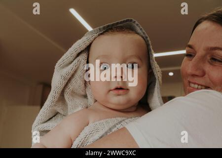 Cute toddler in mother's arms at home Stock Photo