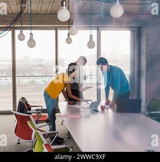 Business colleagues discussing over laptop at table in office Stock Photo