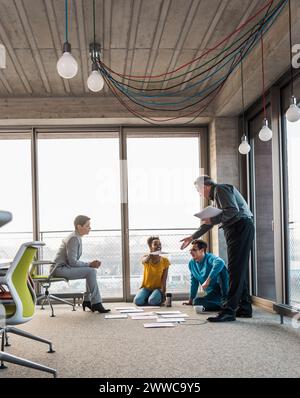 Coworkers working on business plan over documents in office Stock Photo