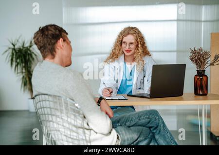 Smiling doctor having discussion with patient in clinic Stock Photo