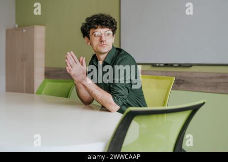 Thoughtful businessman sitting at table in office Stock Photo