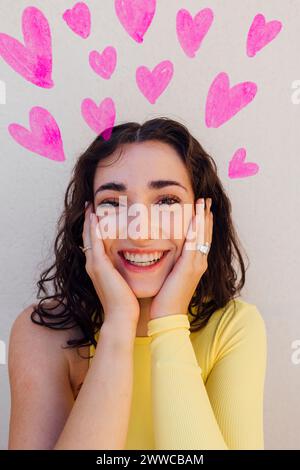 Happy woman with heart doodles against white background Stock Photo