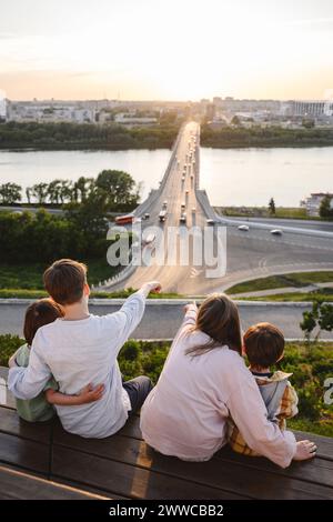 Siblings sitting on bench and looking at Volga river Stock Photo