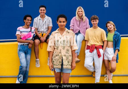 Confident young woman standing in front of group of friends Stock Photo