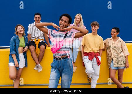 Happy young man standing in front of group of friends Stock Photo
