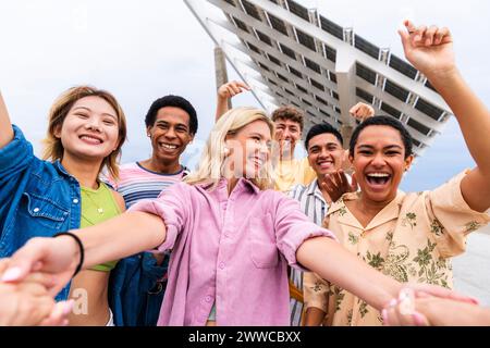 Happy young friends holding hands and having fun together Stock Photo