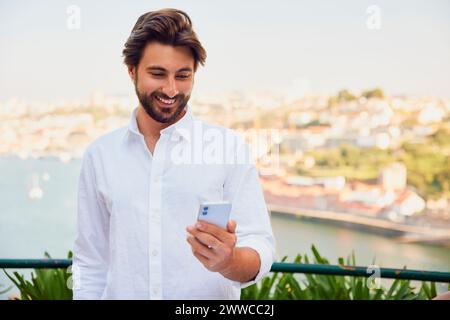 Smiling young man using smart phone Stock Photo
