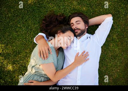 Loving young couple lying on grass Stock Photo