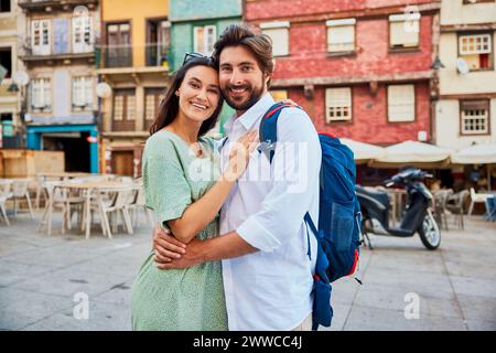 Smiling young couple standing together in front of buildings Stock Photo