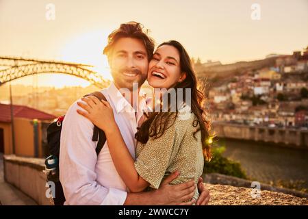 Loving young couple in front of Dom Luis bridge at sunset, Porto, Portugal Stock Photo