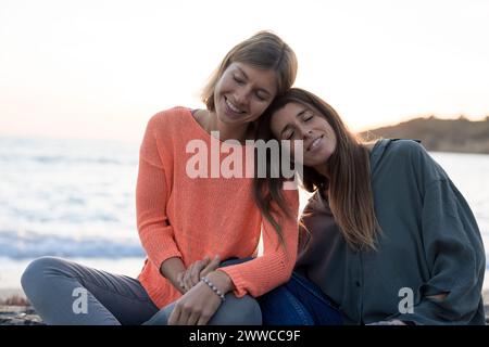 Smiling friends relaxing together at beach Stock Photo